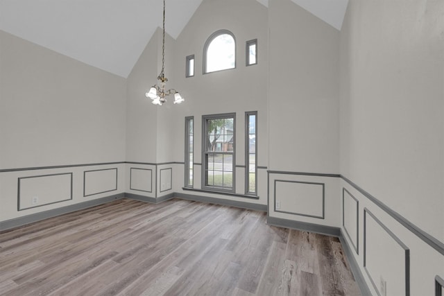 interior space with an inviting chandelier, high vaulted ceiling, and light hardwood / wood-style floors