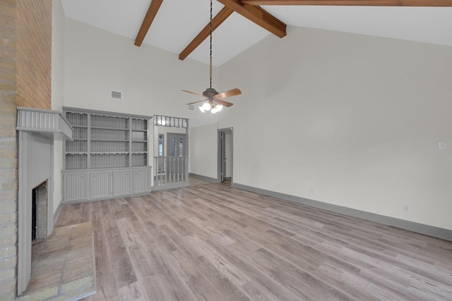 unfurnished living room featuring high vaulted ceiling, light wood-type flooring, beamed ceiling, ceiling fan, and a fireplace