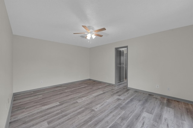 spare room with ceiling fan and light wood-type flooring