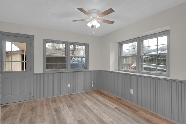 empty room with hardwood / wood-style floors, a textured ceiling, and ceiling fan