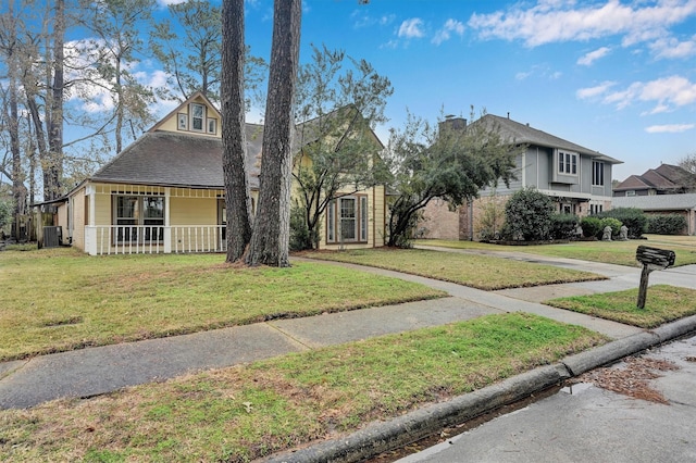 view of front of property with a porch, a front yard, and cooling unit