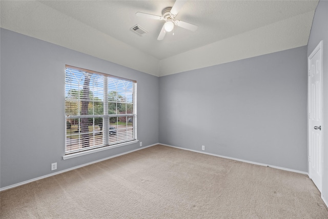 spare room featuring ceiling fan, light colored carpet, and lofted ceiling