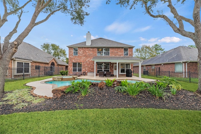 rear view of property with a swimming pool with hot tub, a patio, cooling unit, and a lawn