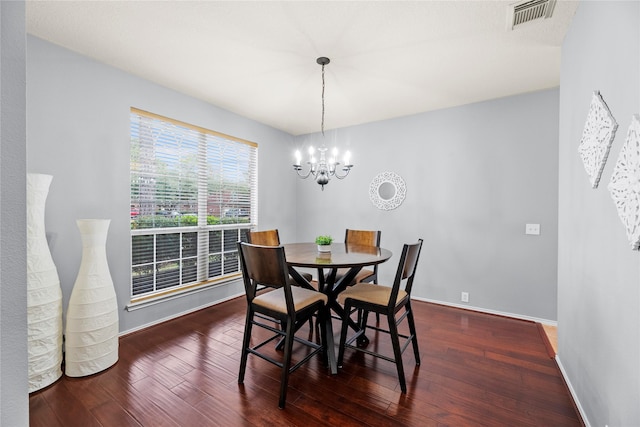 dining area with an inviting chandelier and dark hardwood / wood-style flooring