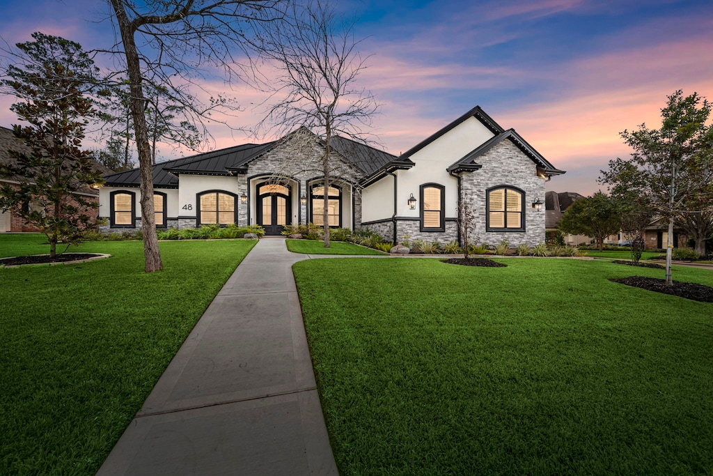 french country inspired facade with a yard