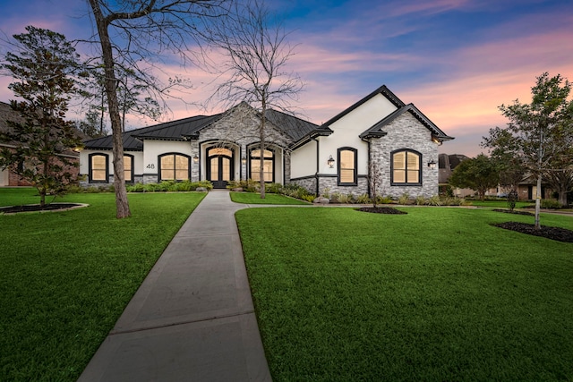 french country inspired facade with a yard