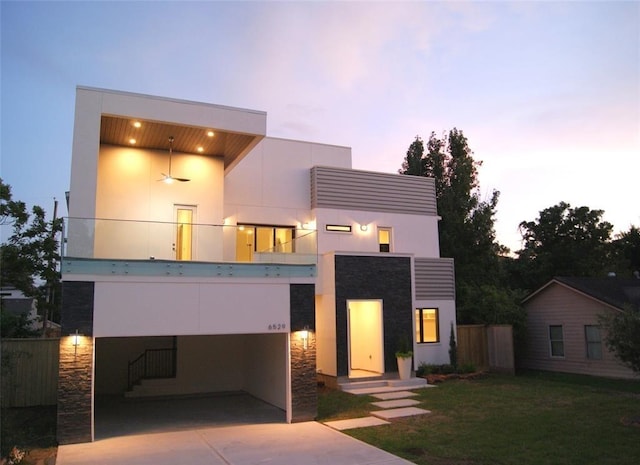 contemporary house featuring a balcony, ceiling fan, and a lawn