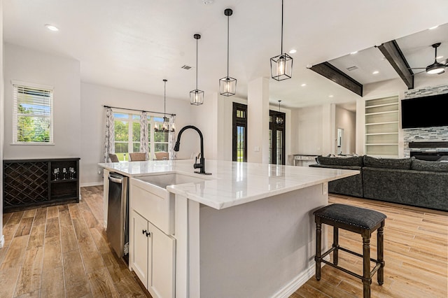 kitchen featuring a kitchen breakfast bar, decorative light fixtures, light stone counters, and a spacious island