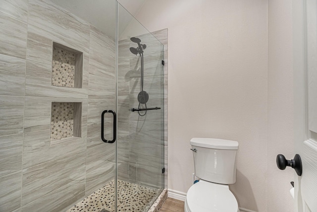 bathroom featuring an enclosed shower and toilet