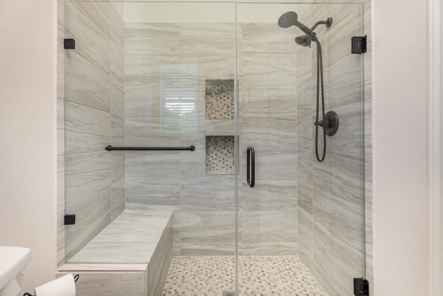 bathroom with an enclosed shower and toilet