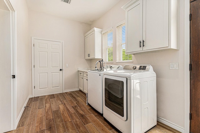 laundry room with independent washer and dryer, cabinets, and dark hardwood / wood-style flooring