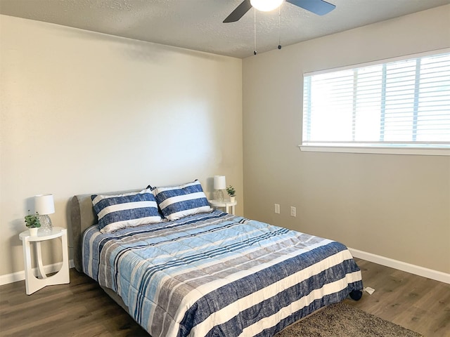 bedroom with dark hardwood / wood-style floors, a textured ceiling, and ceiling fan