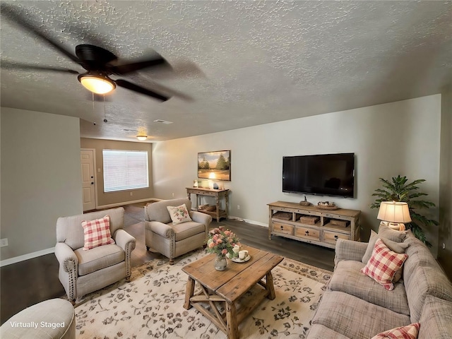 living room with ceiling fan, wood-type flooring, and a textured ceiling