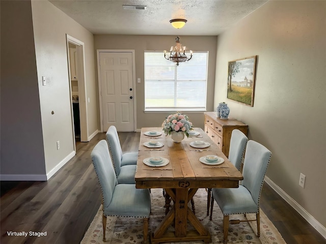 dining room with a notable chandelier, dark hardwood / wood-style floors, and a textured ceiling