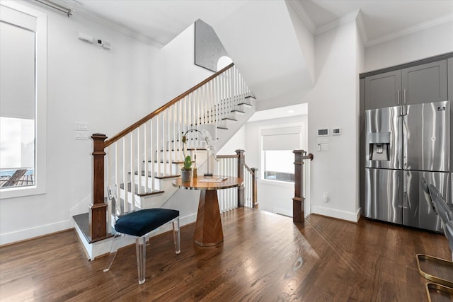 entrance foyer with ornamental molding and dark wood-type flooring