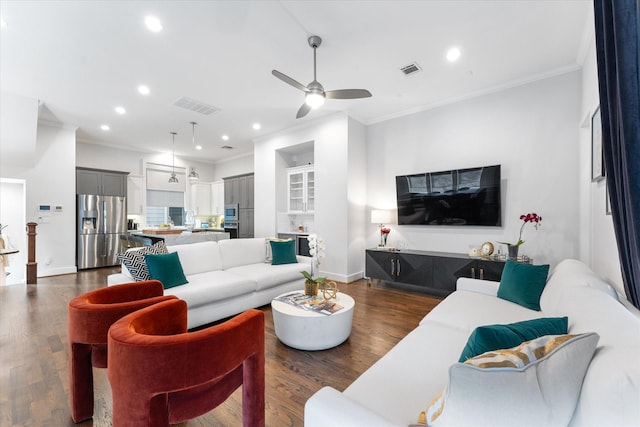 living room featuring dark hardwood / wood-style flooring, crown molding, and ceiling fan