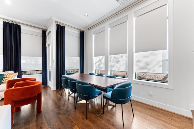 dining space with dark hardwood / wood-style flooring and crown molding