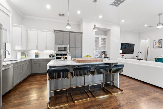 kitchen featuring a breakfast bar, sink, a kitchen island, stainless steel appliances, and backsplash