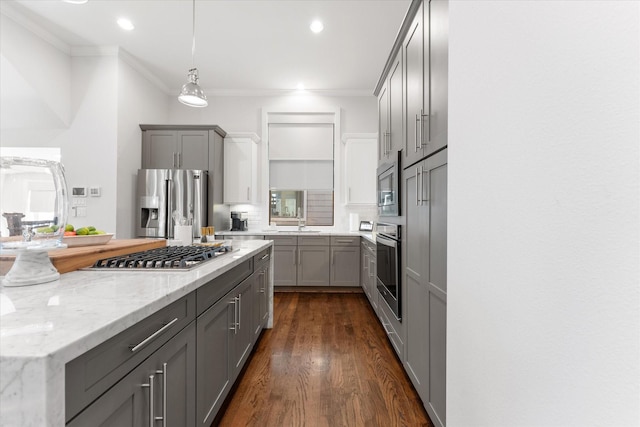 kitchen with decorative light fixtures, dark hardwood / wood-style flooring, gray cabinets, stainless steel appliances, and light stone countertops