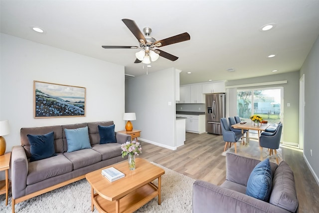 living room featuring ceiling fan and light hardwood / wood-style floors