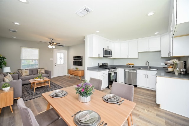 kitchen with stainless steel appliances, sink, and white cabinets