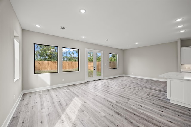 unfurnished living room with french doors and light wood-type flooring