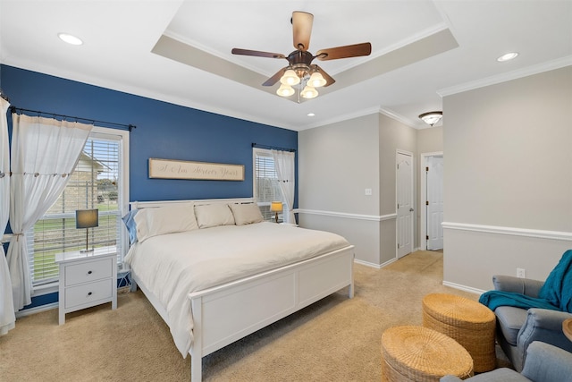 bedroom with crown molding, ceiling fan, a tray ceiling, and light carpet