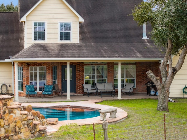 back of property featuring an outdoor living space, a patio, and a lawn