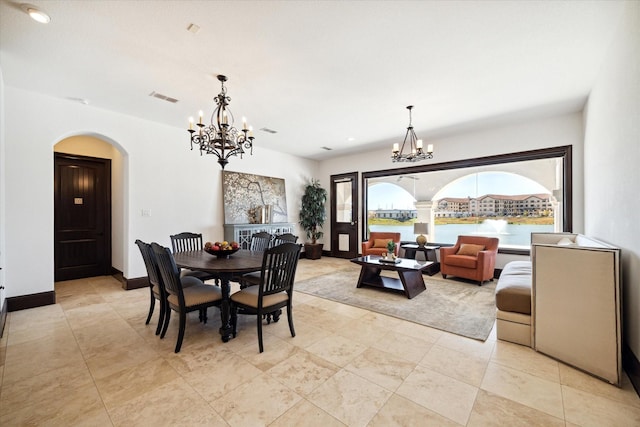 dining area featuring a water view and an inviting chandelier