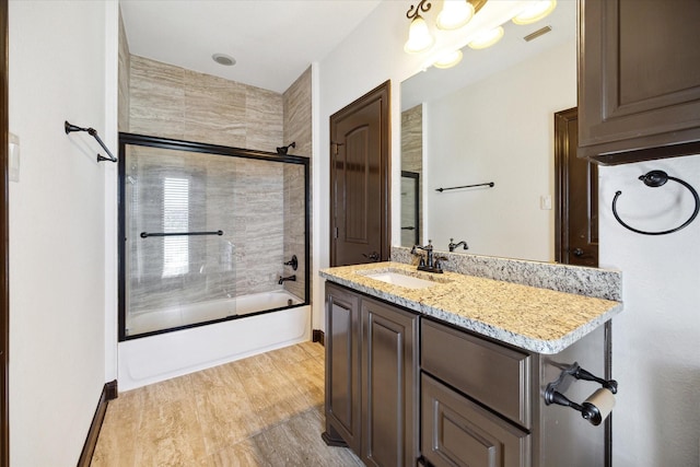 bathroom featuring vanity, shower / bath combination with glass door, and hardwood / wood-style floors