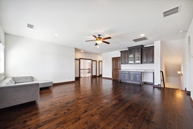 living room featuring ceiling fan and dark hardwood / wood-style floors