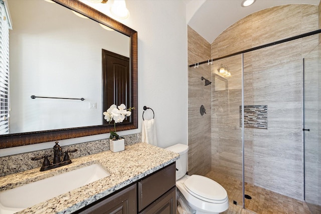 bathroom with vanity, toilet, and a shower with shower door