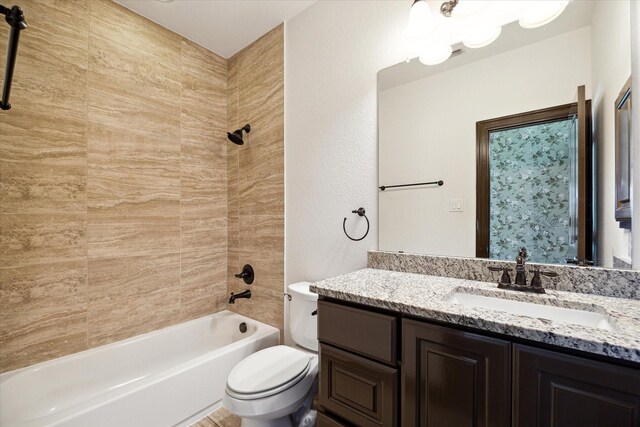 full bathroom with tiled shower / bath combo, vanity, and toilet