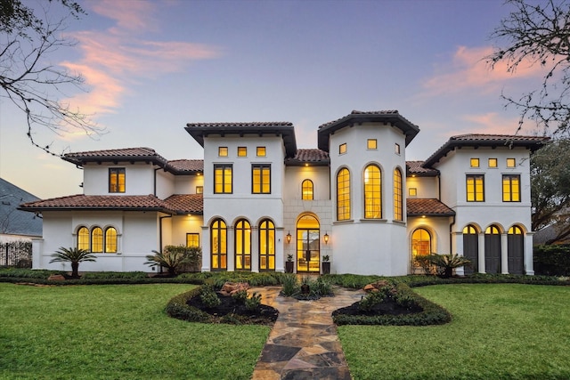 back house at dusk with a yard and french doors