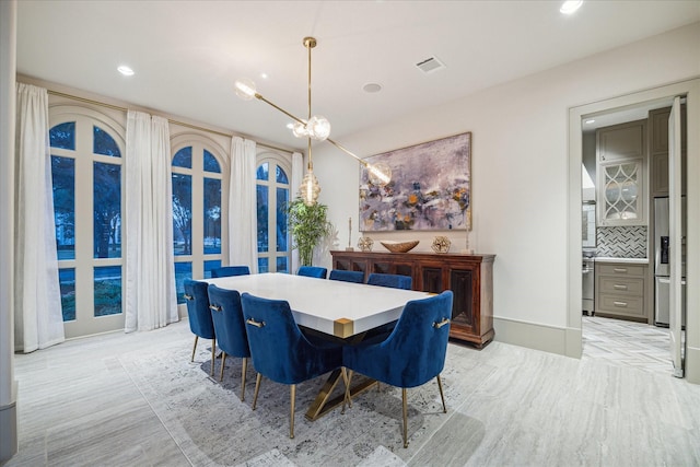 dining space with a notable chandelier and light wood-type flooring