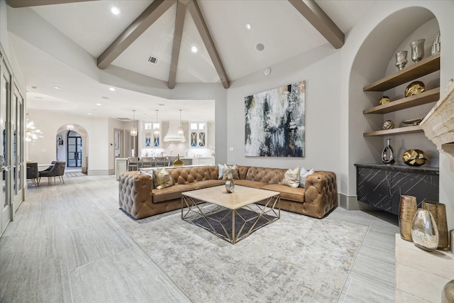 living room featuring beamed ceiling, high vaulted ceiling, and built in shelves