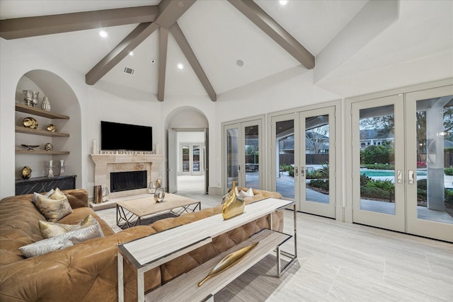 living room featuring beam ceiling, high vaulted ceiling, a fireplace, built in shelves, and french doors