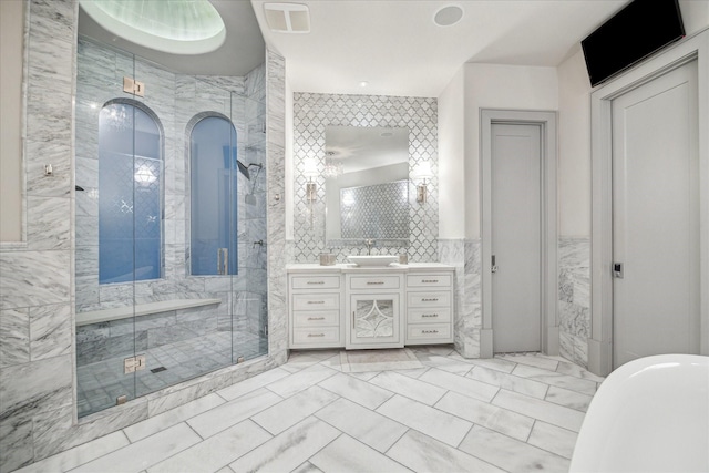 bathroom with tile walls, vanity, and an enclosed shower