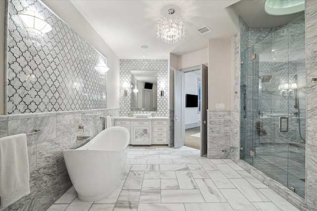 bathroom with tile walls, vanity, and independent shower and bath