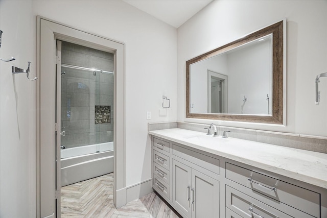 bathroom featuring enclosed tub / shower combo, vanity, and parquet flooring