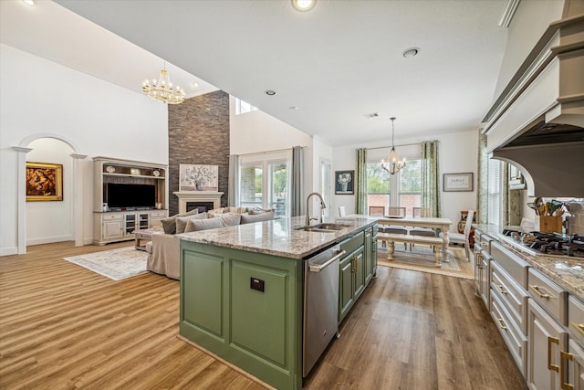 kitchen with appliances with stainless steel finishes, sink, an island with sink, and a notable chandelier