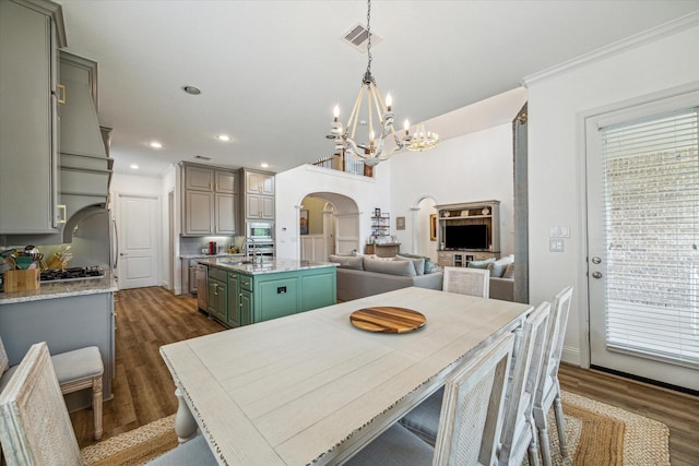 dining area with ornamental molding, dark hardwood / wood-style floors, sink, and a notable chandelier