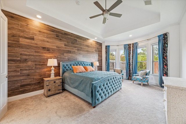 bedroom with ceiling fan, a raised ceiling, and wood walls