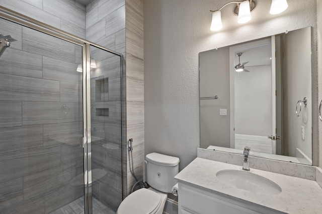 bathroom with vanity, ceiling fan, a shower with door, and toilet