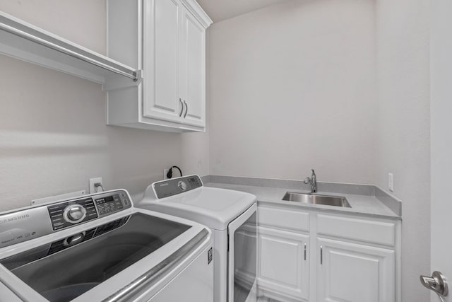 laundry room featuring cabinets, washing machine and dryer, and sink