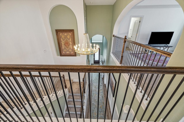 stairway featuring a chandelier