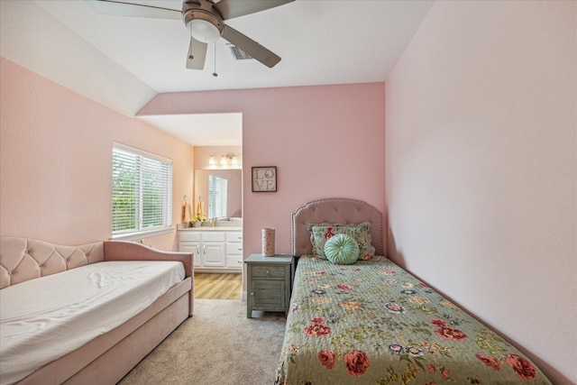 carpeted bedroom featuring vaulted ceiling, connected bathroom, and ceiling fan