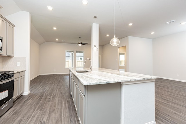 kitchen with visible vents, open floor plan, gray cabinets, stainless steel appliances, and a sink