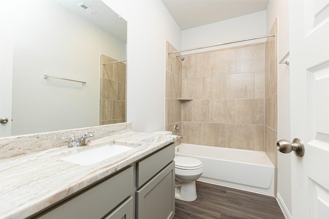 bathroom with bathtub / shower combination, visible vents, toilet, vanity, and wood finished floors