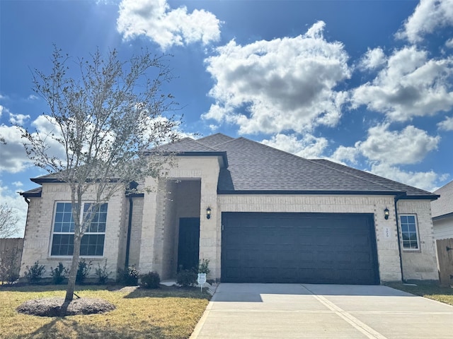 ranch-style home featuring a garage, concrete driveway, and a shingled roof